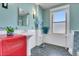 Charming bathroom with red wash stand, white subway tile wainscoting, and a large window at 161 S Pearl St, Denver, CO 80209