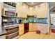 Modern kitchen with stainless steel appliances, green backsplash, and wood cabinets at 161 S Pearl St, Denver, CO 80209