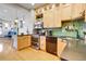 Well-equipped kitchen with stainless steel appliances, wooden cabinetry, and a view into another room at 161 S Pearl St, Denver, CO 80209