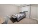 Neutral toned bedroom featuring a bed, bench, and a window for natural lighting at 8440 Rush Creek Ave, Littleton, CO 80125