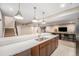 Kitchen with a central island featuring a sink, pendant lighting and seamless flow into other living areas at 8440 Rush Creek Ave, Littleton, CO 80125