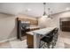 View of the kitchen area, complete with bar seating, stainless steel refrigerator, and pendant lighting at 8440 Rush Creek Ave, Littleton, CO 80125