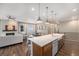 Contemporary open concept kitchen boasts island seating, stainless appliances, and modern living area at 8440 Rush Creek Ave, Littleton, CO 80125