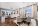 Open-concept living and dining area with a stone fireplace, hardwood flooring, and large windows at 8440 Rush Creek Ave, Littleton, CO 80125