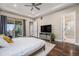 Spacious main bedroom boasts a private patio, ensuite bath, wood floors, and a ceiling fan at 8440 Rush Creek Ave, Littleton, CO 80125