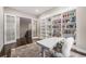 Home office featuring a large desk, comfortable seating, and custom shelving for books at 8440 Rush Creek Ave, Littleton, CO 80125