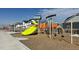 Bright playground featuring a large green slide and climbing structure for children in the community at 8440 Rush Creek Ave, Littleton, CO 80125