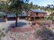 Exterior view of a brown two-story house with a large deck and a three car garage at 351 N Saddle Dr, Idaho Springs, CO 80452