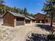 Exterior view of a brown two-story house and a three car garage in a rural setting at 351 N Saddle Dr, Idaho Springs, CO 80452