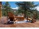 Inviting outdoor seating area with Adirondack chairs arranged around a wooden table on a deck at 351 N Saddle Dr, Idaho Springs, CO 80452