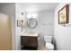 Well-lit bathroom featuring a modern vanity, round mirror, and a classic toilet at 444 17Th St # 603, Denver, CO 80202