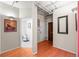 Hallway with hardwood floors, white door, brown closet doors, mirror, and partial bathroom view at 444 17Th St # 603, Denver, CO 80202