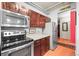 Functional kitchen featuring stainless steel appliances, dark wood cabinets, and exposed ceiling pipes at 444 17Th St # 603, Denver, CO 80202