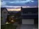 Two-story house featuring a large garage, fenced yard, and mountain views at dusk at 13266 Canopus Dr, Lone Tree, CO 80124