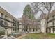 Charming apartment complex courtyard featuring landscaped grounds and mature trees with walkways at 5875 E Iliff Ave # 115, Denver, CO 80222