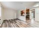 Bright living room with modern gray wood-look flooring and view into the kitchen at 5875 E Iliff Ave # 115, Denver, CO 80222