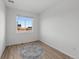 Bright, empty bedroom with large window offering natural light and wood-look flooring at 180 N Edge Cliff St, Castle Rock, CO 80104