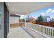 Covered back patio with white railing, overlooking the yard at 180 N Edge Cliff St, Castle Rock, CO 80104