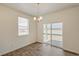 Bright dining area with wood floors, modern chandelier, and sliding glass doors to the backyard at 817 Ledge St, Lochbuie, CO 80603