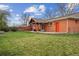 A well-maintained backyard featuring a covered patio, green lawn, and brick accents at 5481 E Tennessee Ave, Denver, CO 80246