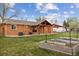 Backyard features a brick home, covered patio, garden beds, and green grass at 5481 E Tennessee Ave, Denver, CO 80246