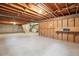 Unfinished basement with exposed wood beams, concrete floor, and utility connections at 5481 E Tennessee Ave, Denver, CO 80246