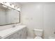 Well-lit bathroom with a large mirror, vanity with storage, and tiled shower at 5481 E Tennessee Ave, Denver, CO 80246