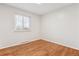 Bright bedroom featuring hardwood floors and natural light streaming through a window with blinds at 5481 E Tennessee Ave, Denver, CO 80246