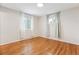 Bright bedroom with hardwood floors and two windows dressed with sheer curtains for natural light at 5481 E Tennessee Ave, Denver, CO 80246