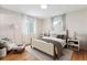 Comfortable main bedroom with neutral colors, natural light, and stylish decor with hardwood floors at 5481 E Tennessee Ave, Denver, CO 80246