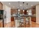 Stylish kitchen featuring stainless steel appliances, granite countertops, a center island, and hardwood floors at 10733 Salida St, Commerce City, CO 80022