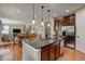 Open-concept kitchen with granite island, stainless steel appliances, hardwood floors, and adjacent dining area at 10733 Salida St, Commerce City, CO 80022