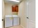 Well-lit laundry room featuring modern washer and dryer units and dark wood cabinetry for storage at 10733 Salida St, Commerce City, CO 80022