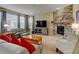 Inviting living room featuring a stone fireplace, comfortable seating, and large windows for natural light at 10733 Salida St, Commerce City, CO 80022