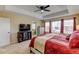 Bright main bedroom with ceiling fan, television, and en suite bathroom featuring a soaking tub at 10733 Salida St, Commerce City, CO 80022