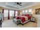 Spacious main bedroom features a tray ceiling, ceiling fan, and large windows with bright red curtains at 10733 Salida St, Commerce City, CO 80022
