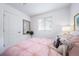 Bedroom with a light pink comforter, a unicorn toy, and a window at 45060 Sunflower Ln, Bennett, CO 80102