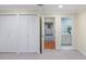 Hallway featuring double closets and an entrance to a bathroom with modern fixtures at 2552 E Alameda Ave # 32, Denver, CO 80209