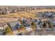 Expansive aerial view of homes bordering the golf course in a peaceful neighborhood, featuring lush greenery and well-maintained lawns at 1870 Alpine Dr, Erie, CO 80516