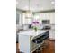 Modern kitchen with an island, white cabinetry, stainless steel appliances, and bar stool seating creating a chef's dream at 1870 Alpine Dr, Erie, CO 80516