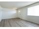 Open living room featuring gray flooring, ample natural light, and a welcoming front door at 8627 Santa Fe Dr, Thornton, CO 80260