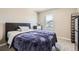This bedroom features neutral carpet, a window view, and a large bed with a gray padded headboard at 764 N Quatar St, Aurora, CO 80018
