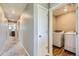 Hallway view leading to a laundry room with a modern washer and dryer at 764 N Quatar St, Aurora, CO 80018
