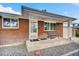 Inviting front porch with brick facade and a cozy seating area, perfect for relaxing outdoors at 61 S 17Th Avdr, Brighton, CO 80601