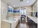 Bright primary bathroom with soaking tub, glass shower door, and artwork overlooking city views at 2001 Lincoln St # 2213, Denver, CO 80202