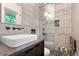 This modern bathroom offers gray textured tiles, a glass shower, & sleek fixtures at 7552 Nikau Dr, Niwot, CO 80503
