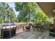 Cozy deck area with a grill, fire pit and seating among mature trees at 7552 Nikau Dr, Niwot, CO 80503