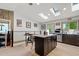 Modern kitchen features a granite island with seating, skylights, stainless appliances, and sleek wooden floors at 7552 Nikau Dr, Niwot, CO 80503