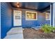 A close up view of the blue exterior siding with a white front door and landscaped green space at 3294 Sentinel Dr, Boulder, CO 80301
