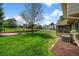 Serene backyard featuring lush green lawn, mature shade tree, and partial view of the enclosed sunroom at 6918 E Long Ave, Centennial, CO 80112